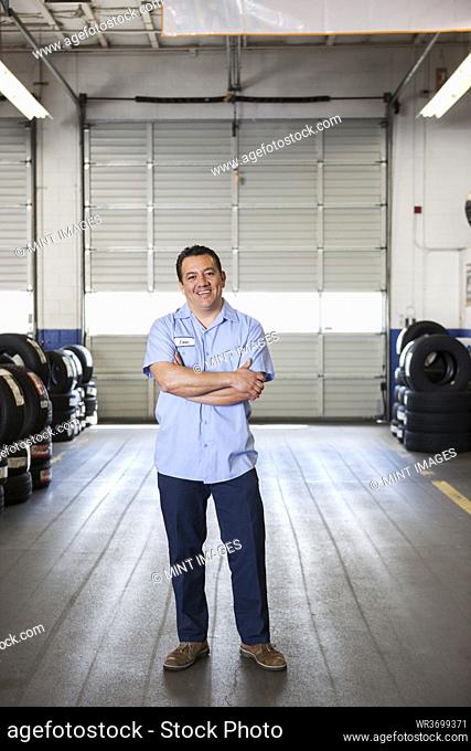 Portrait of Hispanic male owner in auto repair shop