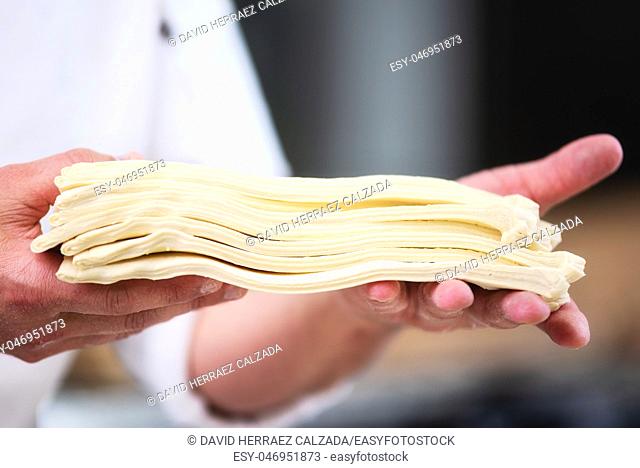 Pastry chef showing dough sheets ready to be rolled to produce croissant