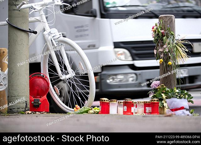 17 December 2021, Lower Saxony, Osnabrück: A so-called ""ghost bike"" and mourning candles stand as a memorial on a busy city street