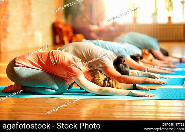 group of people doing yoga exercises at studio