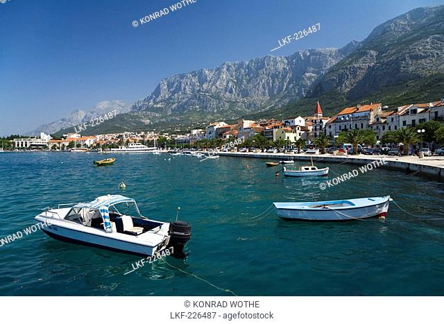 Boats on teh water and houses of Makarska in front of mountain scenery, Dalmatia, Croatia, Europe