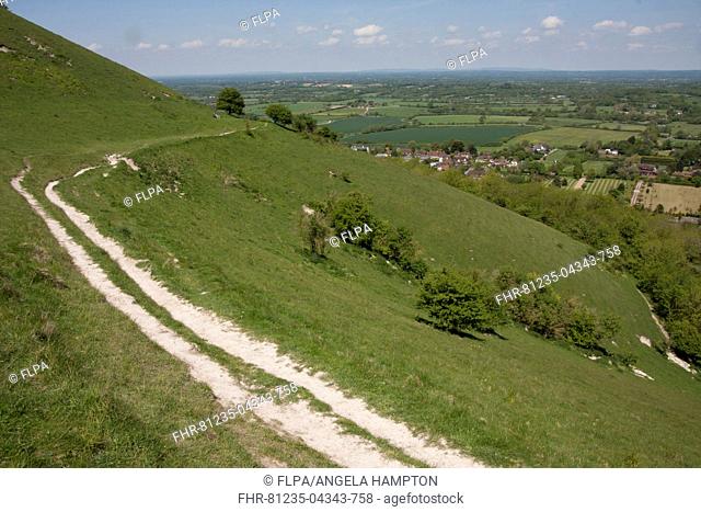 View of chalk escarpment overlooking village and farmland, Fulking, South Downs, West Sussex, England, June