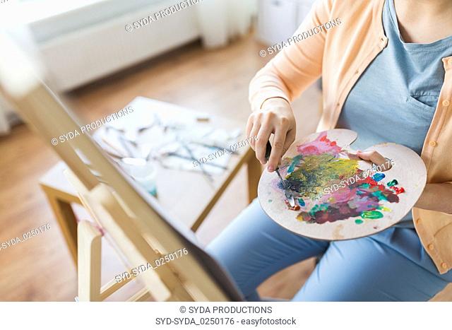 artist with palette knife painting at art studio