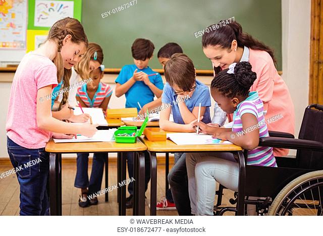 Pupils and teacher working at desk together