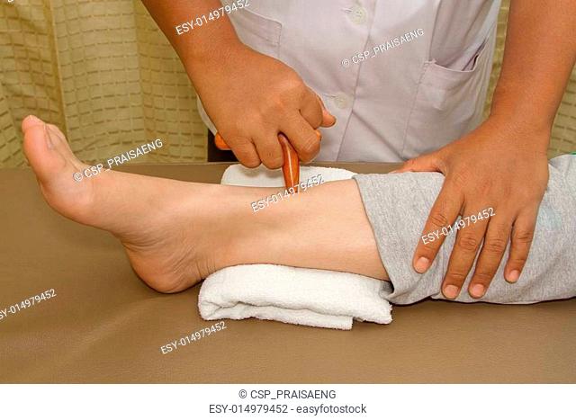 Reflexology foot massage, spa foot treatment by wood stick in h
