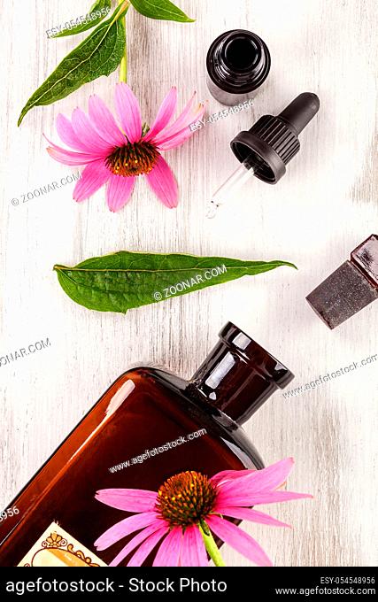 Echinacea flowers extract in glass jar and medicine dropper from above on wooden table