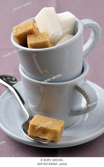 Cup full of white and brown sugar lumps