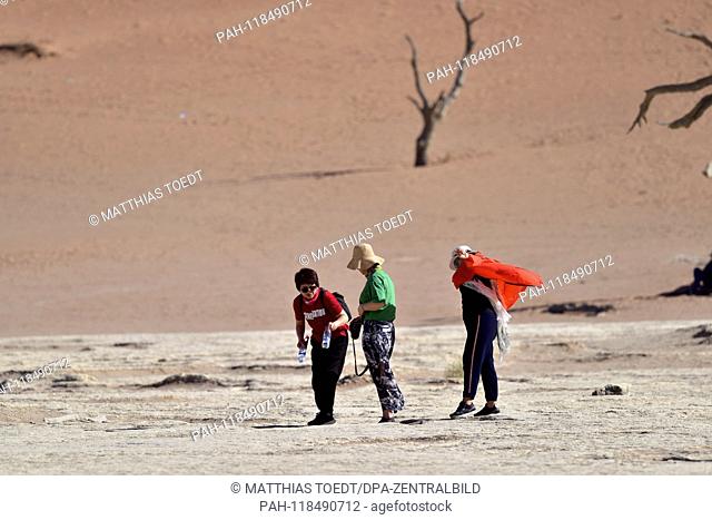Asian tourists take a walk in Dead Vlei, taken on 01.03.2019. The Dead Vlei is a dry, surrounded by tall dune clay pan with numerous dead acacia trees in the...