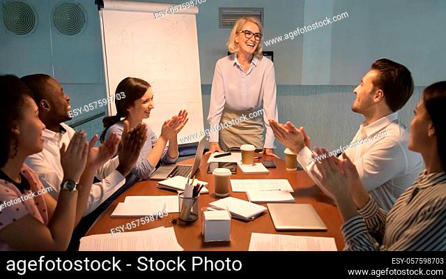 Happy diverse team people young employees interns applaud thank old happy mentor coach for good presentation training celebrating success support leader...