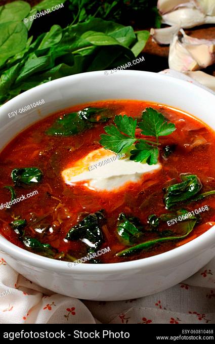 Vegetable bowl, tomato soup with spinach and sour cream. Vertical shot