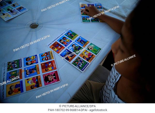 29 June 2018, Guatemala, Escuintla: 'Order', 'Thanks', 'Hope', 'Patience', 'Solidarity', 'Respect' and 'Truth' standing on small cards thatt a little girl is...