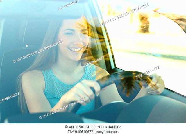 Portrait of a happy attentive driver woman driving a car on the road