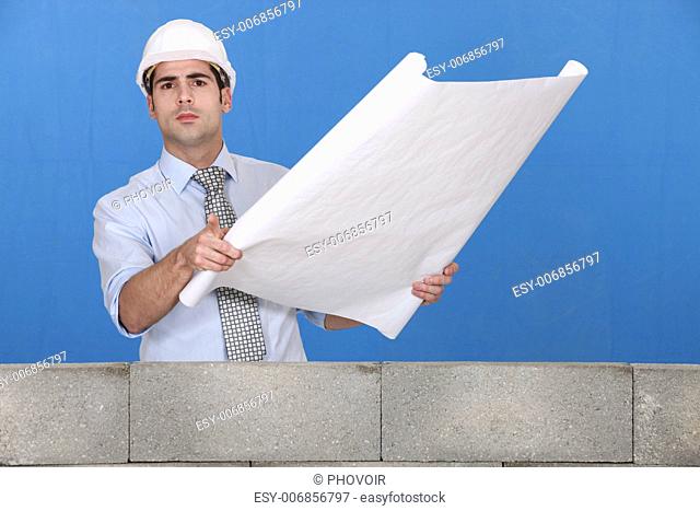Engineer unrolling a technical drawing