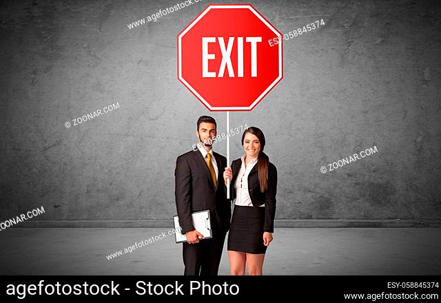 Young business person holding road sign with EXIT inscription, new rules concept