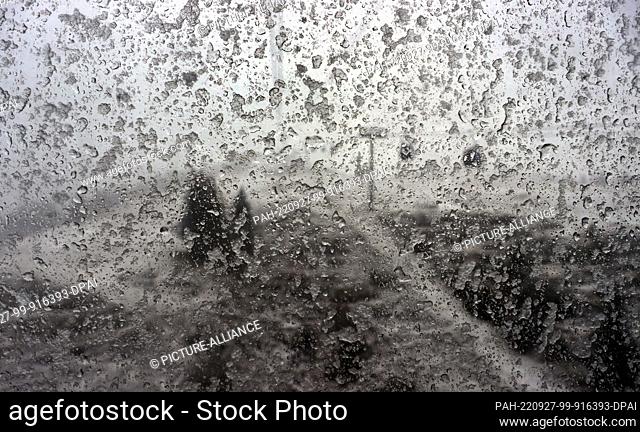 27 September 2022, Bavaria, Oberstdorf: View through the snow-covered window pane of a gondola of the Fellhorn cable car on the landscape covered with fresh...
