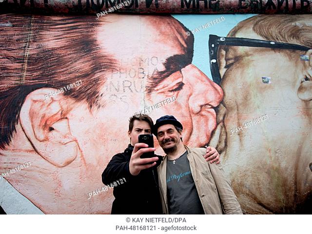 Artist Dimitri Vrubel (R) and son Artjom after cleaning the graffiti painting of the socialist fraternal kiss at the East Side Gallery in Berlin, Germany