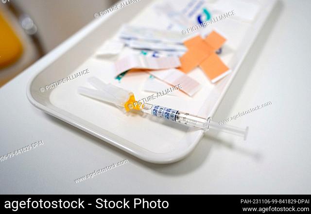06 November 2023, Hamburg: A syringe with the Influvac Tetra flu vaccine lies on a table in a treatment room in the vaccination center at the Institute for...