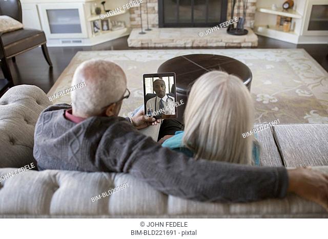 Older couple video chatting with digital tablet