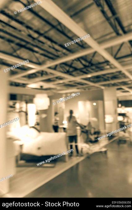 Vintage tone motion blurred customer shopping at bedroom gallery in ready-to-assemble furniture store in America