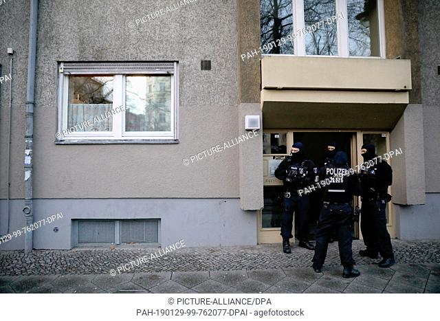 29 January 2019, Berlin: SEK officers are standing in front of a house in Kreuzberg during an operation after a raid on a security van in October