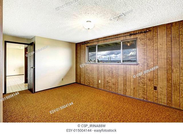 Empty room with wood plank paneled wall and view of Gig Harbor b