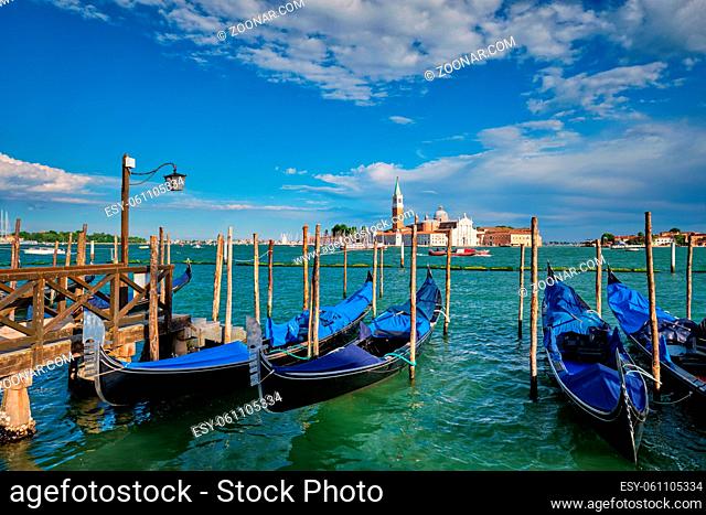 Gondolas and in lagoon of Venice by Saint Mark (San Marco) square with San Giorgio di Maggiore church in background in Venice, Italy