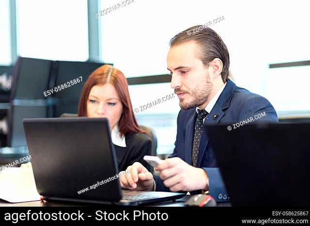 Business people working on laptops in modern office
