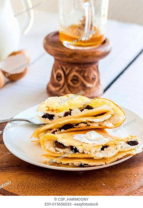 thin pancakes stuffed with cheese, prunes and sour cream, milk