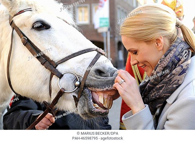 News reader Judith Rakers scratches the lip of a horse from the Prinzengarde carnival horses during the ZDF show ""Wetten, dass..)"" (Wanna bet that