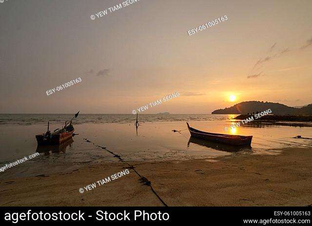 Fisherman boats park at the sea coastal in golden sunset hour