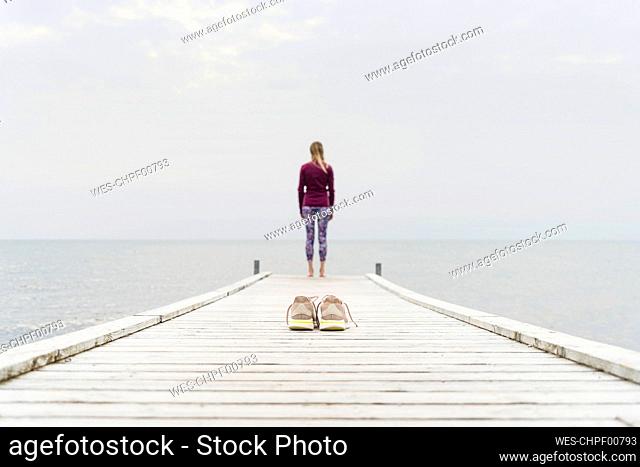 Woman looking at sea while standing on pier