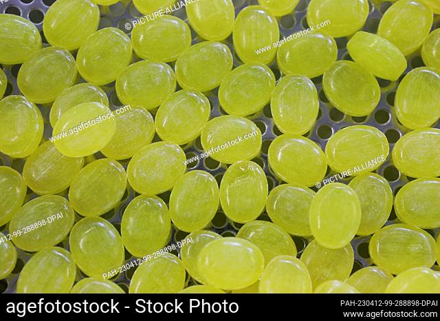 12 April 2023, Saxony-Anhalt, Oschersleben: Lemon candies run across the table of a production plant at Bodeta Süsswaren GmbH during the visit of...