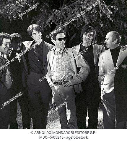 Italian writer and director Pier Paolo Pasolini standing with Italian actors Franco Citti and Ninetto Davoli and French actor Laurent Terzieff on the set of the...