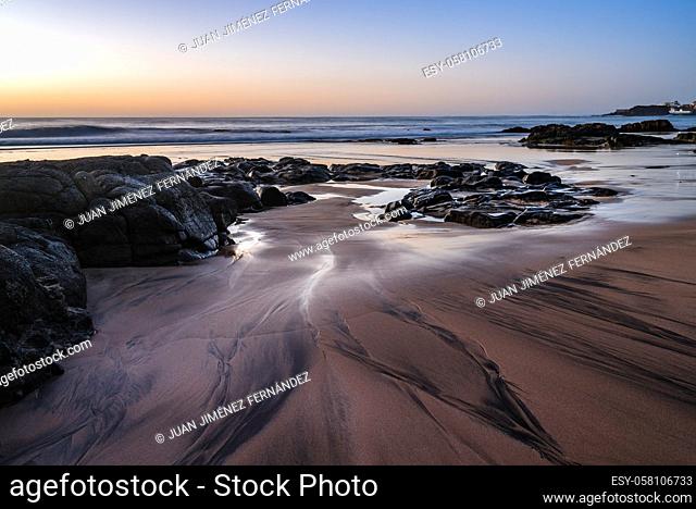 Scenic view of sandy beach with rocks against sky during sunset. El Cotillo, Fuerteventura, Canary Islands. Holidays concept