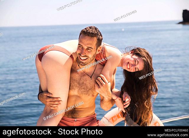 Smiling man having fun with girlfriend on boat at vacation