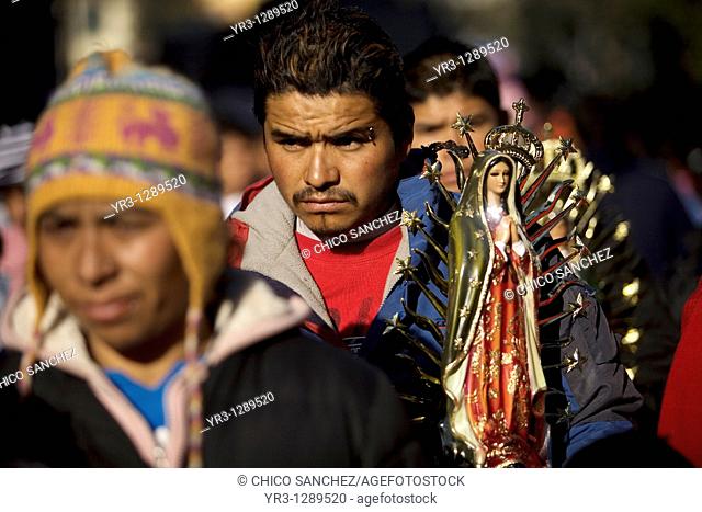 A pilgrim carries a statue of the Our Lady of Guadalupe outside the Our Lady of Guadalupe Basilica in Mexico City, December 11
