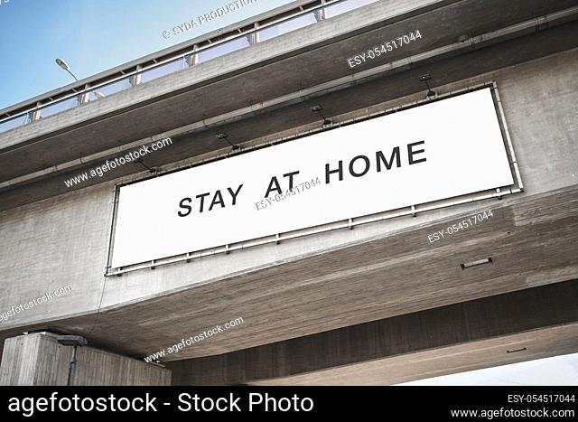 billboard with stay at home words on bridge