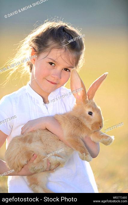 Girl with her rabbit on meadow, Upper Palatinate, Bavaria, Germany, Europe