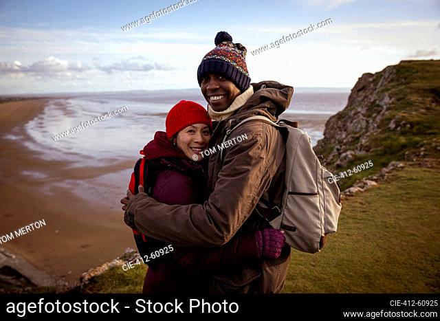 Portrait happy. hiker couple hugging on cliff overlooking beach