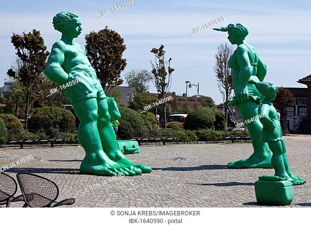Green sculptures, Reisende Riesen im Wind or Travelling Giants in the Wind, by the artist Martin Wolke in front of the station in Westerland on Sylt island