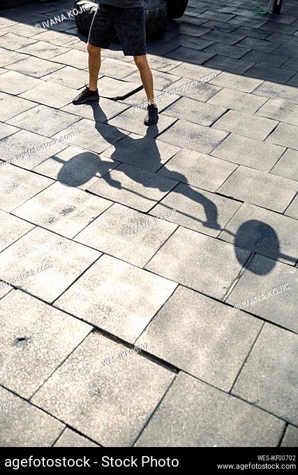Shadow of man lifting weights exercising at rooftop gym