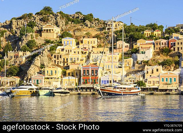 Late afternoon sun over neo-classical mansions of Gialos port, Symi Island, Dodecanese, Greece