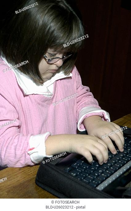 Little girl with Down Syndrome utilizing a communication board for assistance with her homework