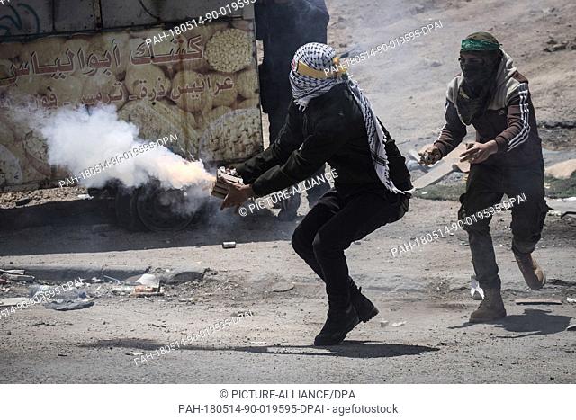 A Palestinian protester launches fireworks towards Israeli Security Forces during clashes following a protest against the US Embassy move to Jerusalem