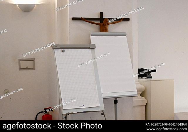 21 July 2022, Bavaria, Munich: Flipcharts stand in front of a cross during the press conference of the Archdiocese of Munich and Freising to present the 2021...