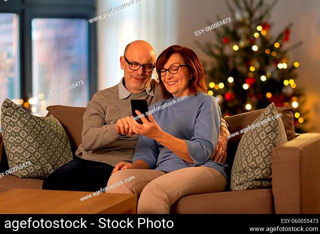 senior couple with phone at home on christmas