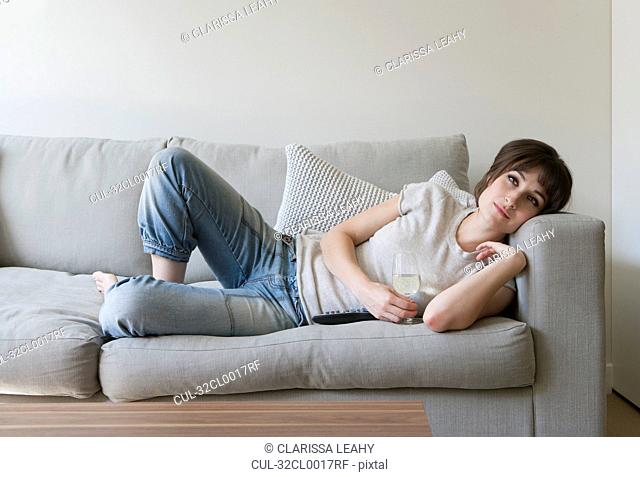 Woman drinking wine on couch