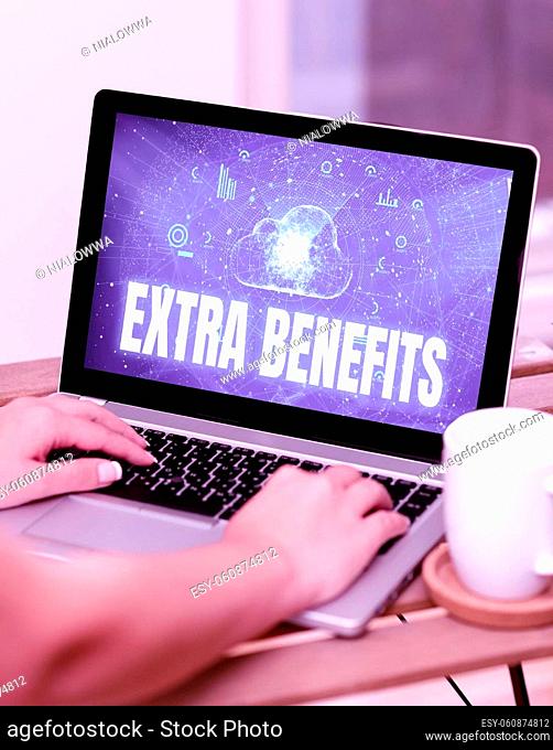 Conceptual caption Extra Benefits, Concept meaning Additional compensation Bonus Subsidies Incentives Allowances Both Hands Typing On Laptop Next To Cup And...