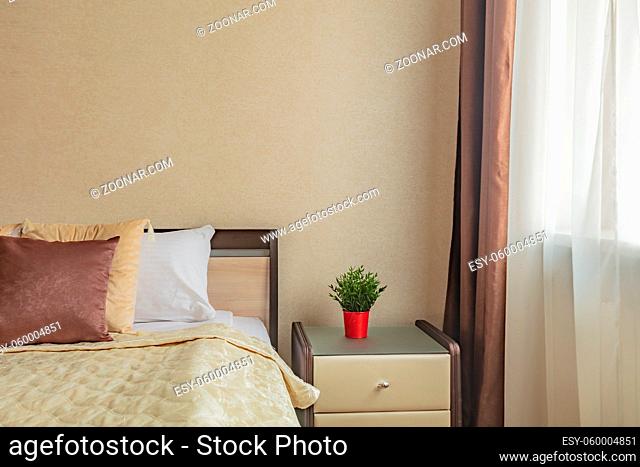 pillow on bed and nightstand in cozy comfortable bedroom in beige color