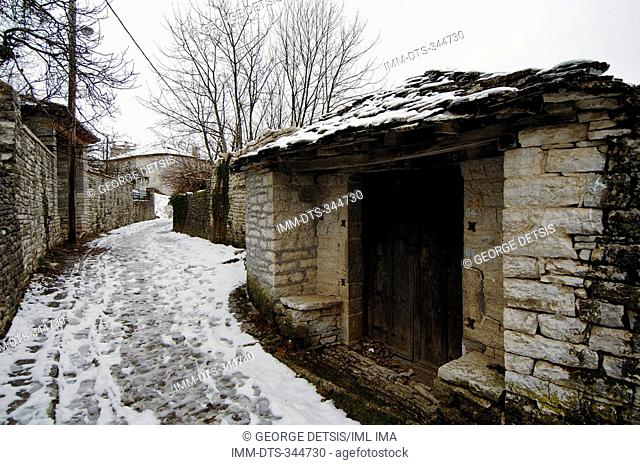 Pathway in Monodendri village covered in snow. Monodendri, Zagorohoria, Ioannina, Greece, Europe